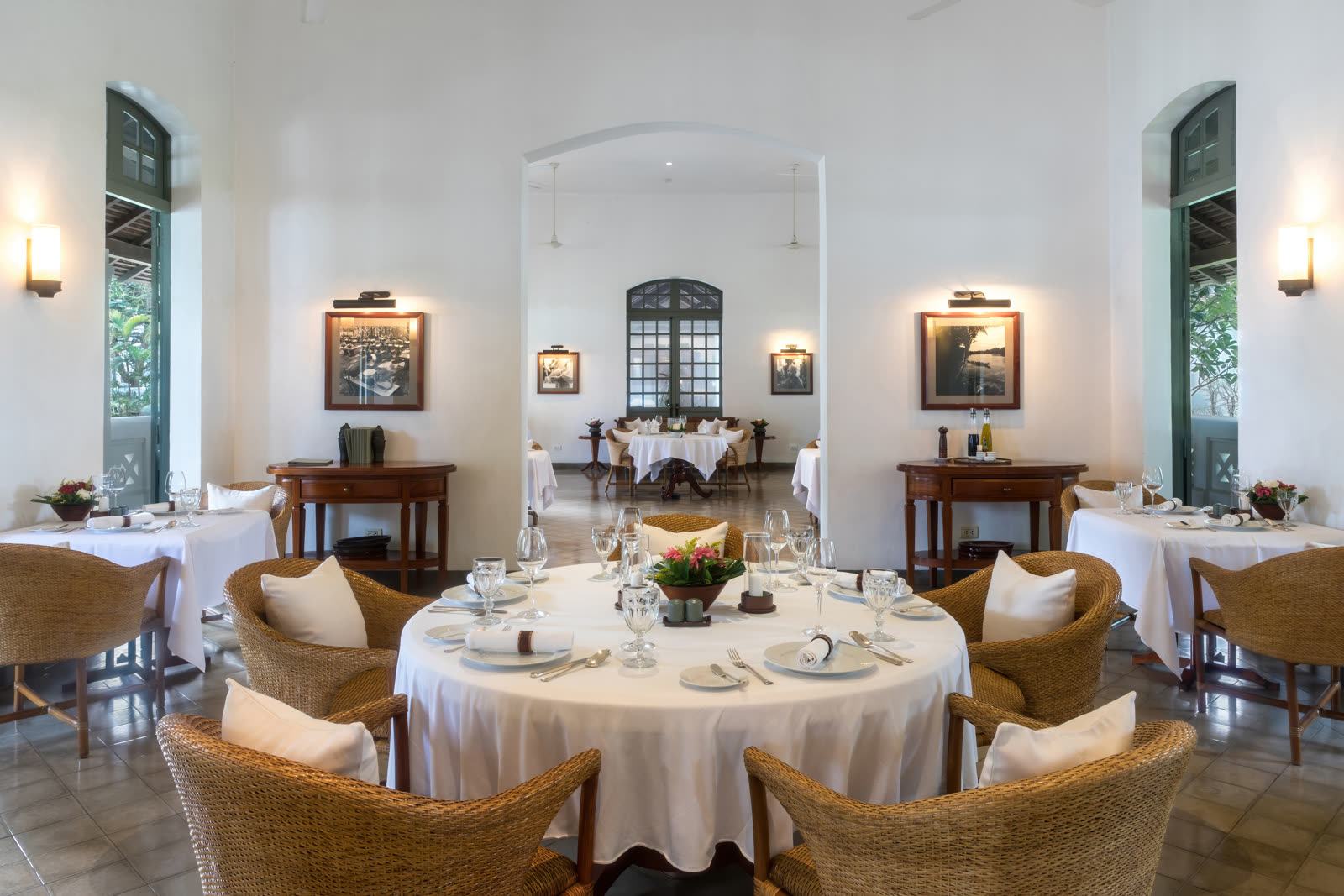 Elegant dining room with round tables dressed in white and warm wall light