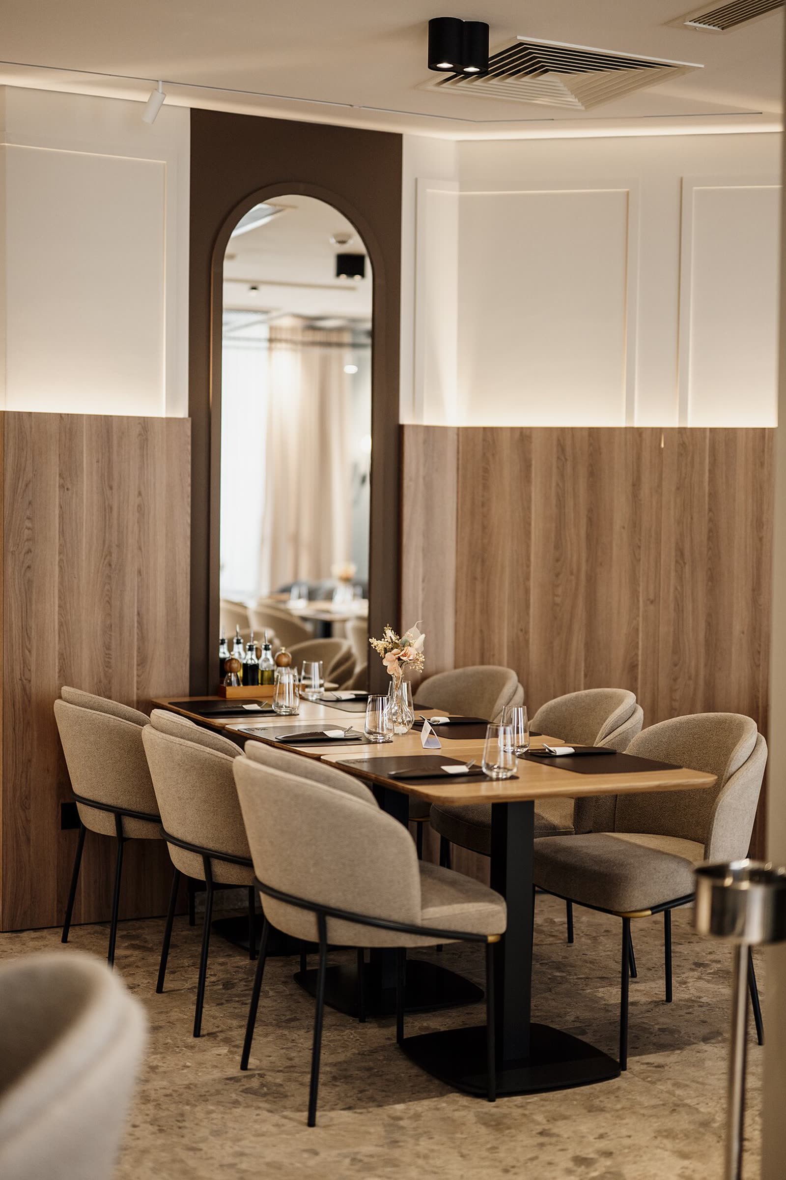 Modern restaurant dining room with wood-paneled walls and a table set for dinner