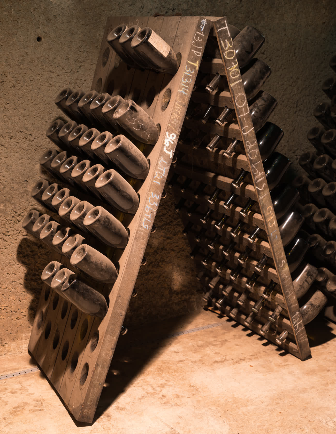 Traditional riddling rack for aging wine bottles in a cellar