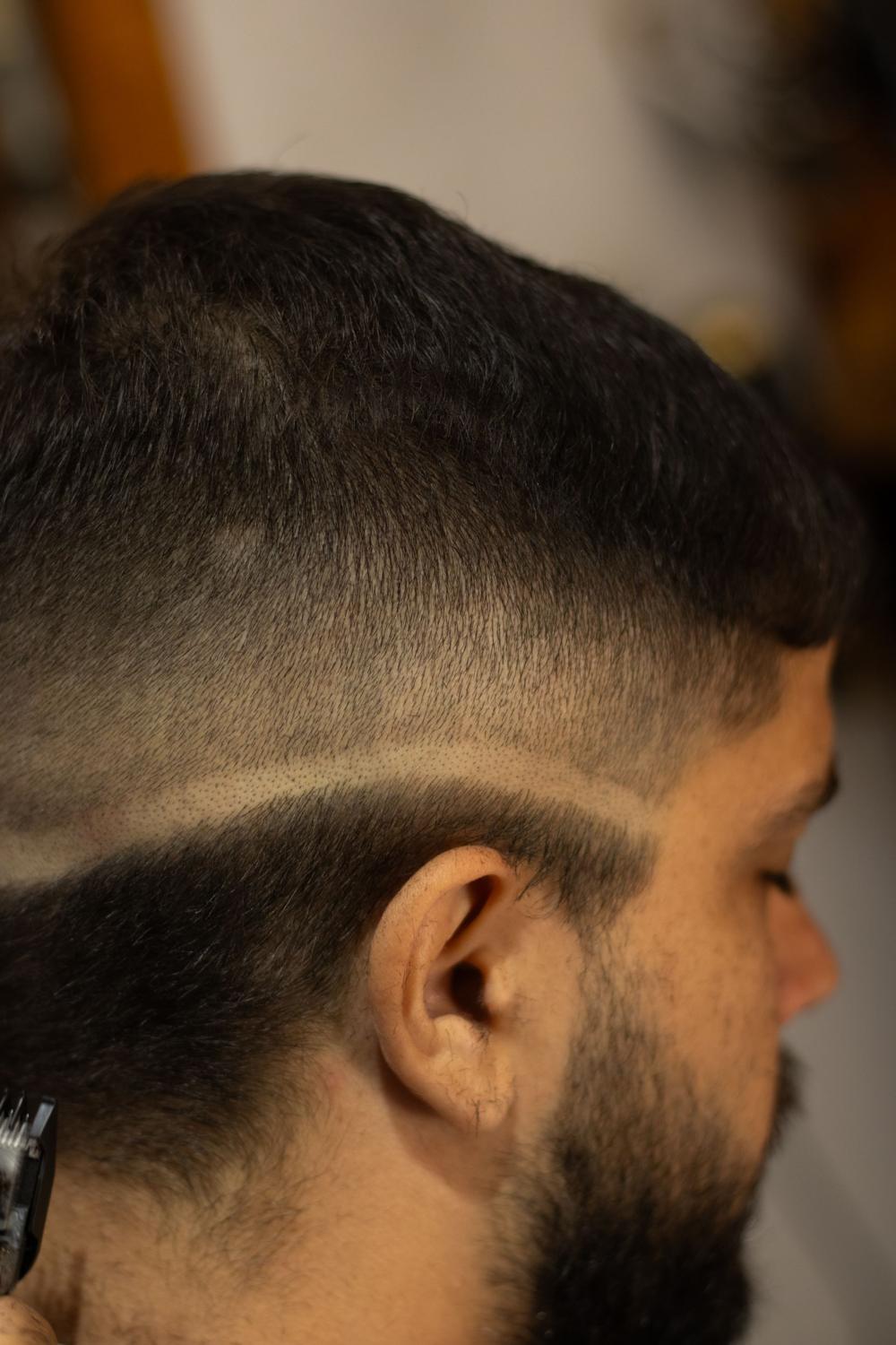 De aproape: trecerea de la piele la fir, cu o linie dreaptă deasupra urechii și barba lăsată lungă.