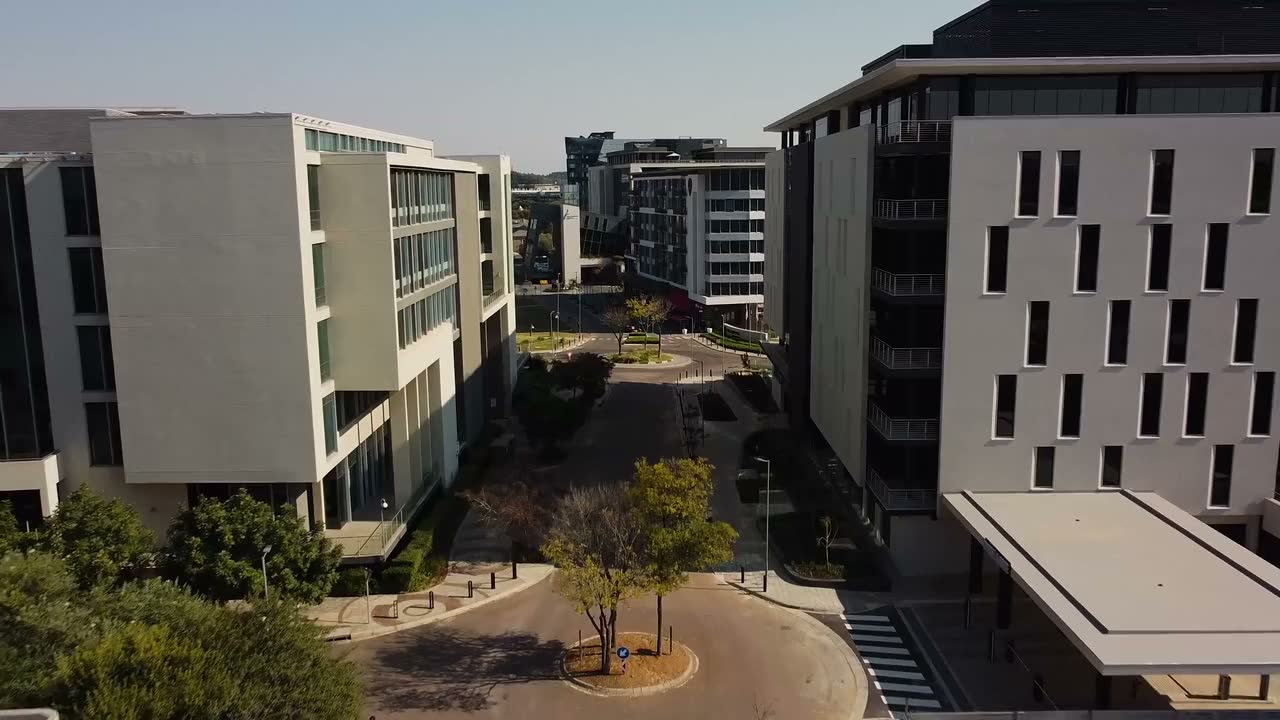 Aerial drone view flying between modern buildings